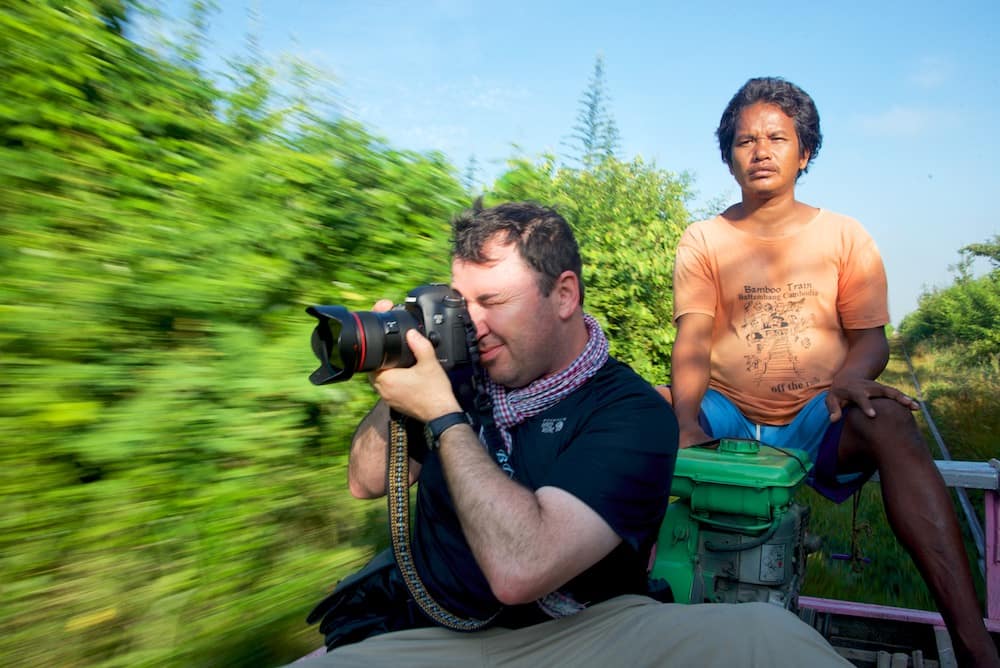 Brian Cruickshank shooting on the bamboo train near Battambang, Cambodia by Ralph Velasco.